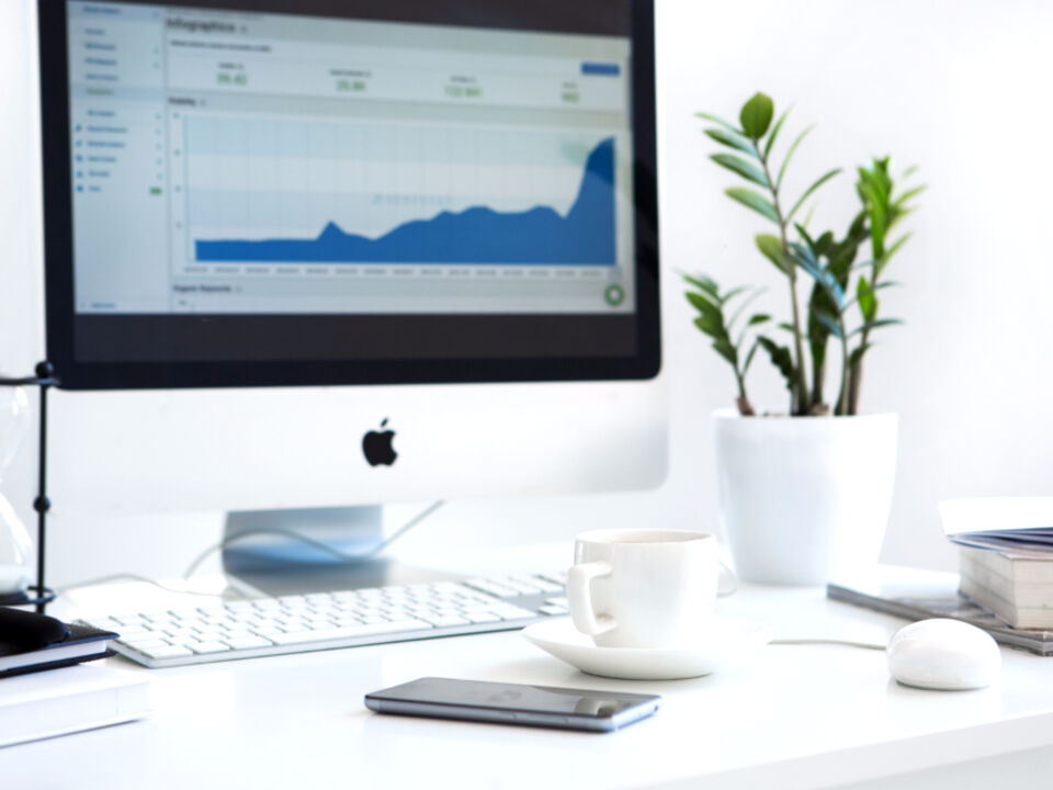 A bright desk with a computer showing charts