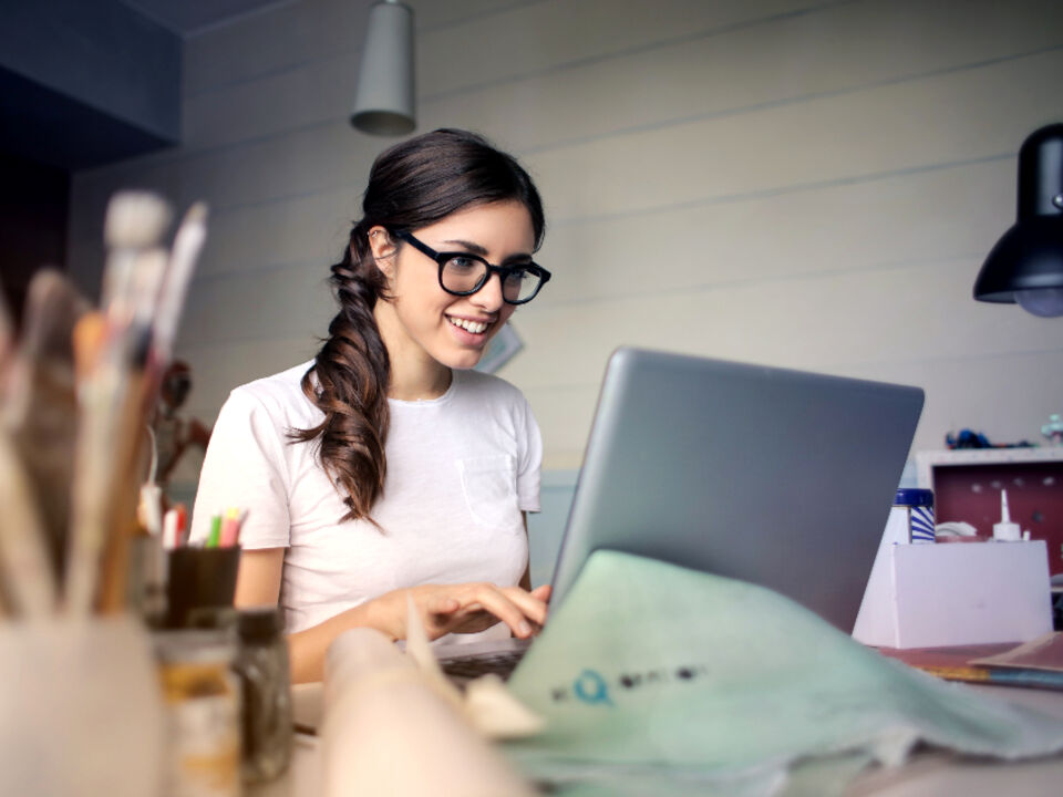 A person studying with a laptop and a notebook